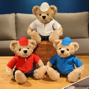 Three dressed plush teddy bears in red, blue and white on a cozy wooden table