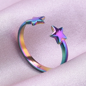 Macro shot of an adjustable iridescent star ring on a smooth purple silk background