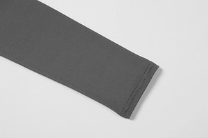Close-up of double-needle stitching on the cuffs of a grey long-sleeved jumpsuit