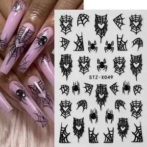 Halloween nail art stickers featuring black spider web and heart patterns on long pink nails