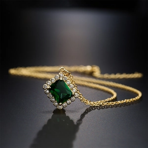 18K gold plated necklace with square emerald zircon pendant on a dark reflective surface