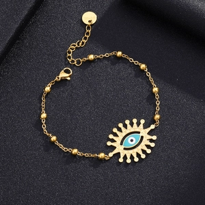 Detail of gold stainless steel evil eye bracelet featuring blue enamel eye and beads