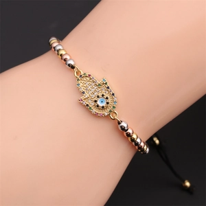 Macro detail of the Hamsa Hand charm with multicolor zircons on a tri-color beaded bracelet