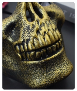 Close-up of vintage skull mask showing aged gold texture and detailed teeth finish