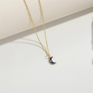 Classic golden crescent moon necklace with blue enamel pendant and small rhinestone detail