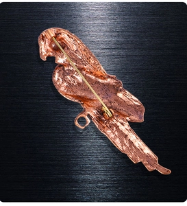 Macro detail of the rose gold parrot brooch back showing the safety pin and pendant loop
