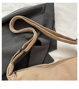 Detail of beige corduroy crossbody bag with metallic zipper and adjustable strap