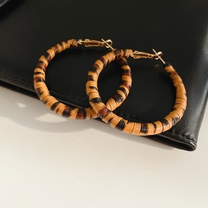 Gros plan de boucles d'oreilles créoles en cuir léopard avec fermoirs en métal doré