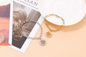 Close-up of gold and silver chain bracelets with crystal-studded circular charms