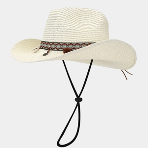Dettaglio cappello cowboy in paglia con fascia etnica, conchiglie e cordino regolabile
