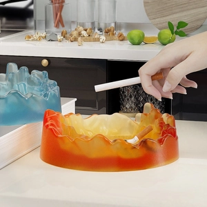 Detailed close-up of mountain peak resin ashtray in vibrant orange and ice blue matte finish
