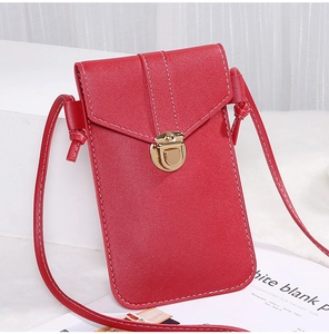 Detail of red pebbled leather phone bag featuring a golden metal lock and long strap