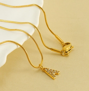 Detailed view of gold plated snake chain with sparkling rhinestone initial A pendant
