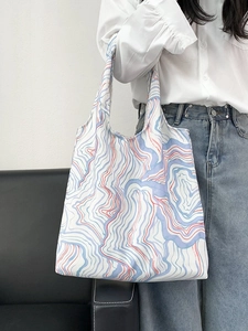 Floral canvas tote bag with blue and red wave patterns shown on model shoulder