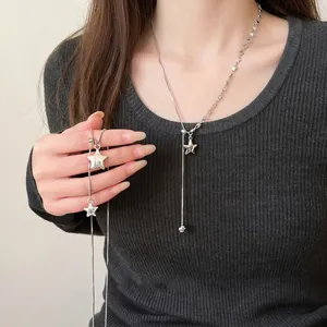 Asymmetric silver star tassel long necklace for women on dark grey sweater
