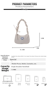 Detail view of cream shoulder bag with blue heart embroidery and pleated strap measurements
