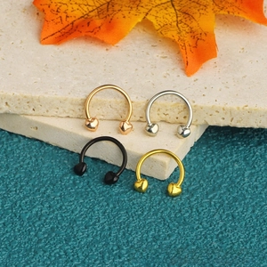 Macro view of four-color stainless steel horseshoe nose rings with heart-shaped ends