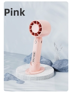 Pink handheld mini fan with detachable base on decorative blue stones