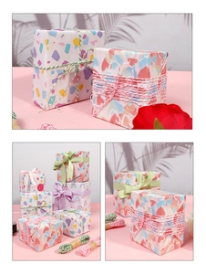 Close-up of heart and rainbow gift wrapping paper with decorative ribbons and cotton twine