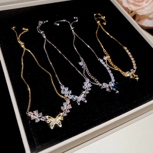 Detail of CZ butterfly bracelets in gold and silver with adjustable sliding clasps