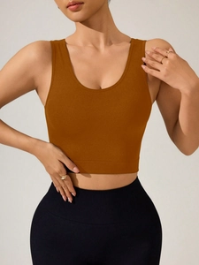 Détail du débardeur de sport ocre avec larges bretelles et ourlet côtelé de soutien