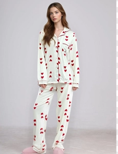 Close-up of white waffle knit pajamas featuring red heart patterns and contrast piping