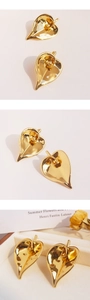 Detail of luxury gold-plated leaf earrings with artistic texture and metallic finish