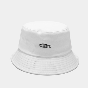 Detailed close-up of white cotton bucket hat with black fishbone embroidery and stitched brim