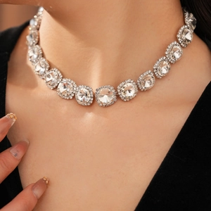 Close-up of sparkling rhinestone choker necklace on model featuring a silver metal fringe