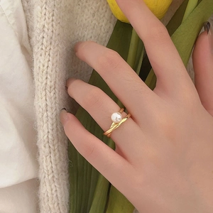 Elegant 925 silver cross pearl ring with gold finish shown on model with flowers