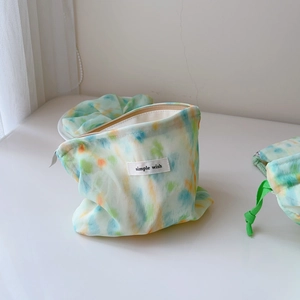 Close-up of pastel tie-dye cotton cosmetic pouch with metal zipper and woven label