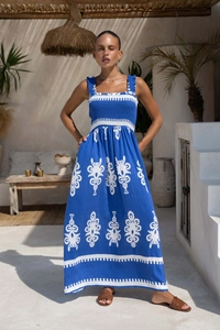 Detail of blue bohemian maxi dress showing ethnic embroidery and smocked bodice texture