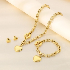 Detailed view of chunky gold heart pendant necklace and bracelet set with OT toggle clasp