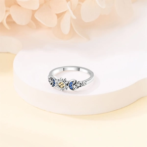 Macro view of silver star and moon ring featuring sun motif and colorful gemstones