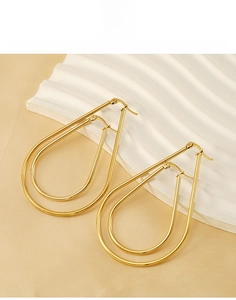 Detail view of large double-layer gold teardrop hoop earrings in titanium steel