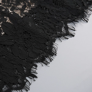 Close-up of black eyelash lace detail with intricate floral patterns and scalloped edges