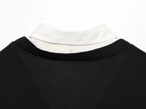 Dettaglio dell'abito in maglia a coste nero con colletto in popeline bianco e design a strati