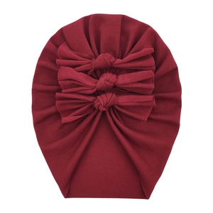 Close-up of soft burgundy cotton baby turban featuring three stylish knotted bows