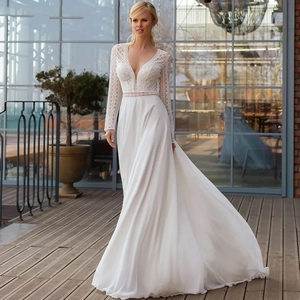 Elegant white V-neck wedding dress with long lace sleeves and flowing chiffon train