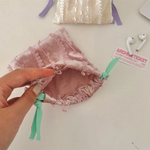 Pink velvet drawstring pouch with lace trim and green cord showing internal storage space