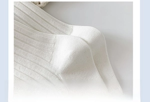 Détail de chaussettes en coton blanc côtelé montrant la couture renforcée au talon