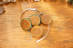 Macro shot of crazy horse leather tape measure with vintage floral embossing on wooden desk