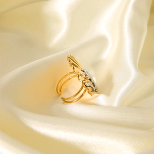 Detailed macro of gold-plated shell-shaped ring with three pearls on silk background