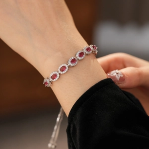 Détail du bracelet vintage en zircon rouge ovale avec chaîne argentée ajustable au poignet