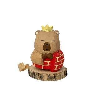 Hand-carved wooden cartoon monk ornament with crown and red heart shell on base