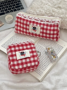 Plaid wool fabric organizer set with pencil case and cosmetic bag on a study desk