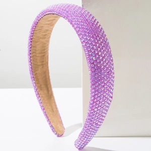 Close-up of a sponge headband with purple rhinestones and shimmering diamond texture