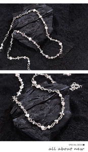 Detailed macro view of silver poker motif chain showing heart and clover links with clasp