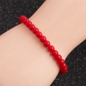 Vue macro d'un bracelet de perles rouges minimaliste avec des perles rondes polies