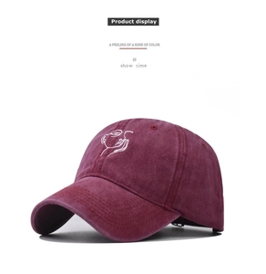 Dettaglio cappellino bordeaux in cotone lavato con ricamo ritratto a linee bianche